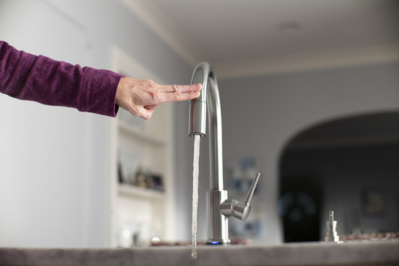 A hand tapping the faucet, showing it can be turned on and off with a tap.