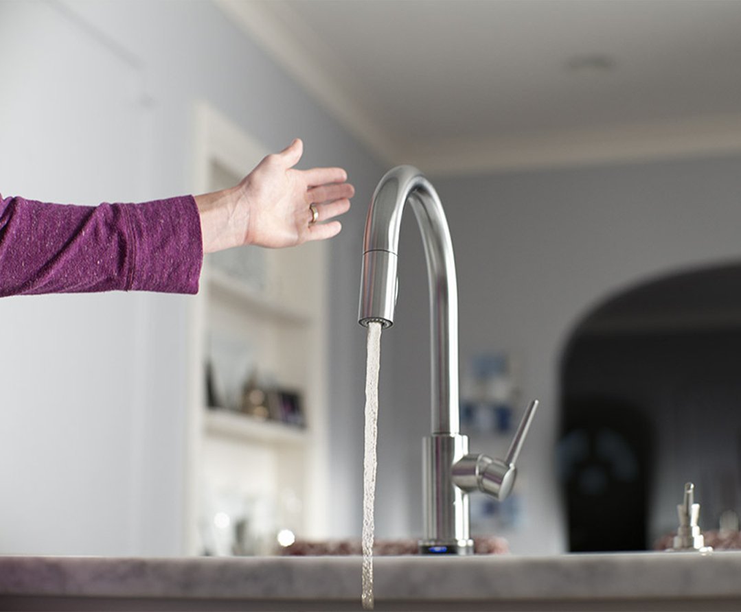 Person waving their hand near the Touch + Touchless Kitchen Faucet